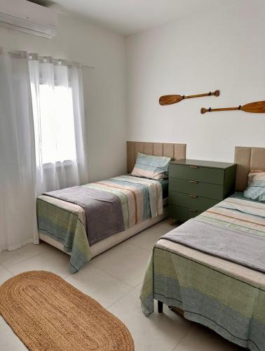 a bedroom with two beds and a window at Casa espaçosa com piscina, a 2 quadras do mar! in Guaratuba