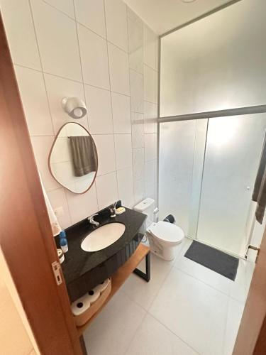 a bathroom with a sink and a toilet and a shower at Casa espaçosa com piscina, a 2 quadras do mar! in Guaratuba