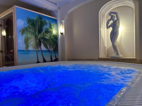 a large blue swimming pool in a room with a painting at Hotel Polaris in Świnoujście