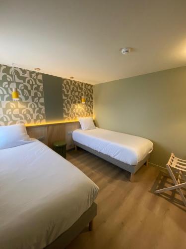 a hotel room with two beds and a chair at Green Hôtels Poitiers in Poitiers