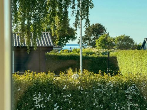 a field of flowers with a street light and a building at Renovated Holiday Home With Sea View In Skåstrup in Bogense