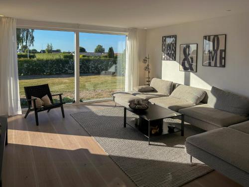 a living room with a couch and a table at Renovated Holiday Home With Sea View In Skåstrup in Bogense