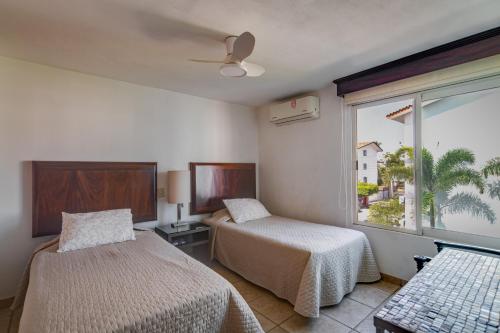 a hotel room with two beds and a window at departamento de lujo, Puerto Vallarta. Mexico in Puerto Vallarta
