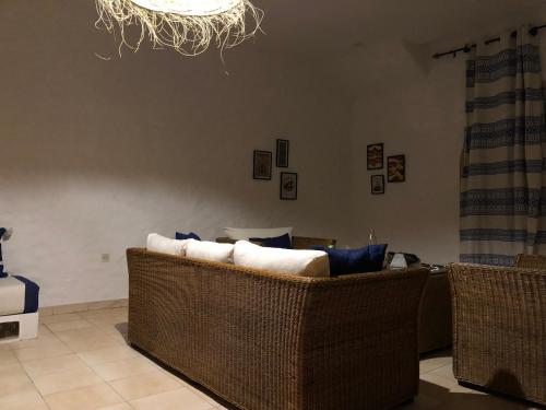 a living room with two wicker chairs and a chandelier at Villa Thalassa in Oualidia