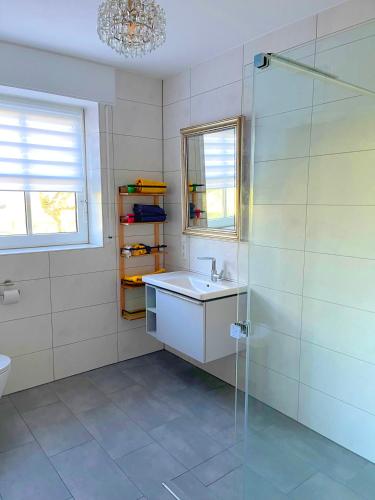 a bathroom with a sink and a glass shower at Beimannskath in Kalkar