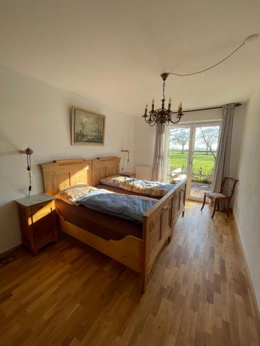 a bedroom with a large bed and a large window at Beimannskath in Kalkar