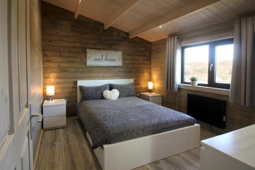 a bedroom with a bed with two night stands and a window at Connemara luxury log out in Camus Eighter