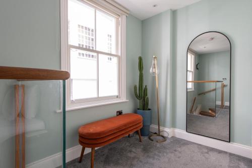 a dressing room with a stool and a mirror at Soho Harmony Haven: Chic 2-Bed, 2-Bath Urban Retreat in London