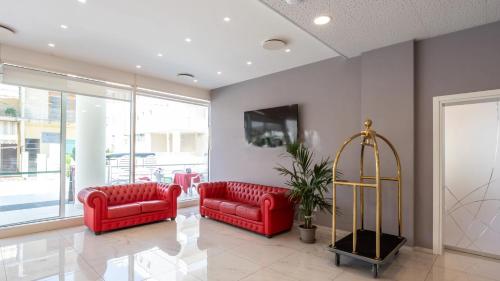 a lobby with two red couches and a tv at HOTEL SETTIBI 20m dalla spiaggia in Giulianova