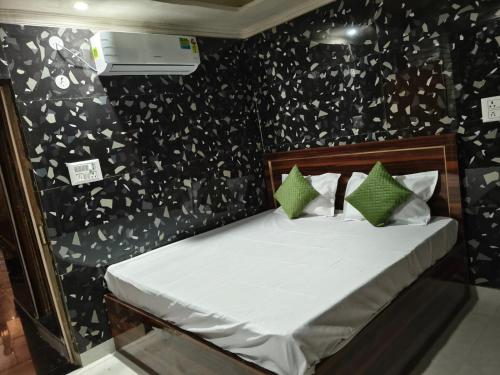 a bedroom with a bed with green pillows and a wall at Braj Darshan Bhawan in Jāmb