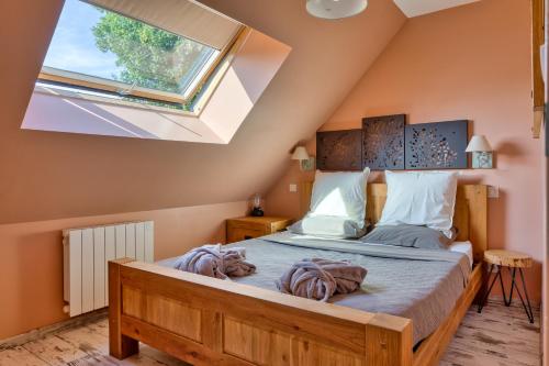 a bedroom with a large bed with a skylight at Villa Argonne - Cottages & Spa Privatif in Ouville-la-Rivière