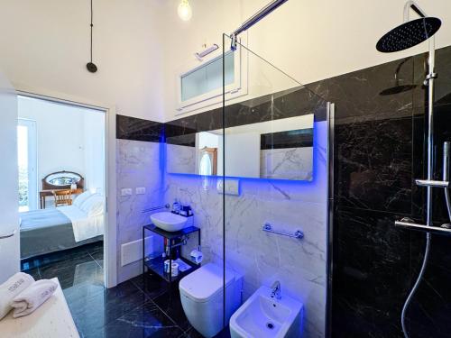 a bathroom with a shower and a sink and a toilet at Villa Nauna - Beachfront Villa with Garden & Sea-View Terrace Santa Caterina - Marea Stays Collection in Nardò