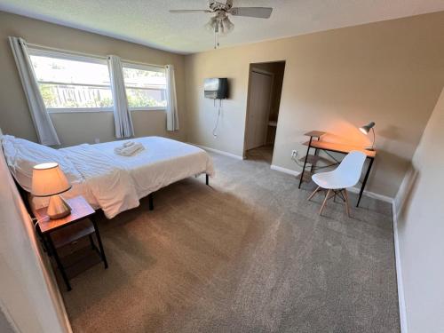 a bedroom with a bed and a table and a desk at Host Hubble Private Rooms in Southern Lakeland in Lakeland