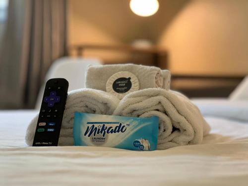 a pile of towels and a remote control on a bed at Host Hubble Private Rooms in Southern Lakeland in Lakeland