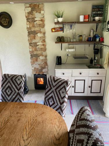 a kitchen with a table and chairs and a stove at Metsanõmme puhkemaja ja saun in Lümati