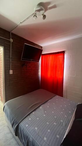 a bedroom with a bed with a red curtain at Maximina Home in Comodoro Rivadavia