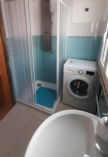 a bathroom with a shower and a washing machine at Bilocale Su Lizzu de Erminia in La Caletta