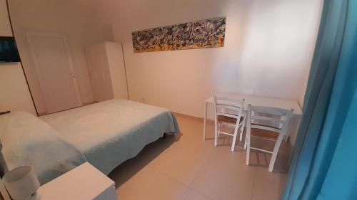 a bedroom with a bed and a table and chairs at Bilocale Su Lizzu de Erminia in La Caletta