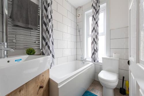 a bathroom with a tub and a toilet and a sink at The Haven Lodge in Gillingham