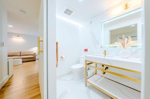a white bathroom with a sink and a toilet at Green Island Inn in Fort Lauderdale