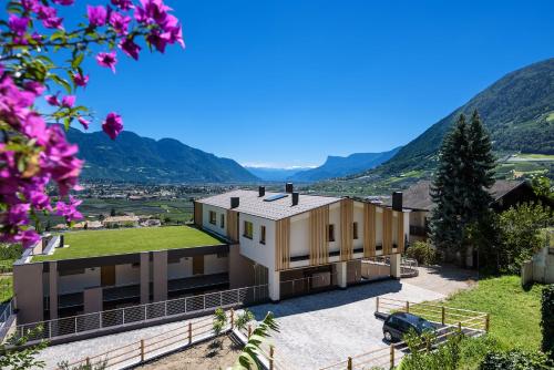 a house with a green roof with mountains in the background at Panorama Residence Öhlerhof in Lagundo