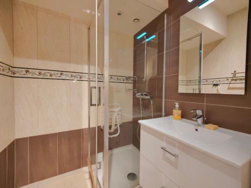 a bathroom with a shower and a sink and a mirror at Les Capucins - Élégance au Cœur de Remiremont in Remiremont