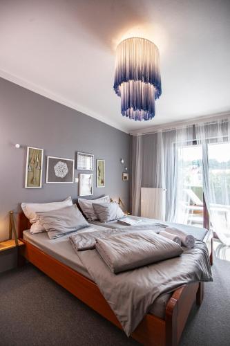 a bedroom with a large bed and a chandelier at Apartmani Vale 2 in Hvar