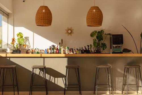 a bar with stools and a counter with drinks at BOHOTEL Messonghi - Designer's Hotel in Mesongi