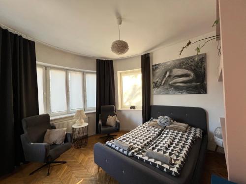 a bedroom with a bed and a chair and windows at Apartamenty Rajcza in Rajcza