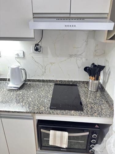 a kitchen counter with a tablet on a counter top at Fortuna Apart in General Roca