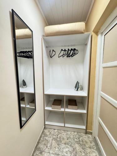 a walk in closet with white shelves and a mirror at Fortuna Apart in General Roca