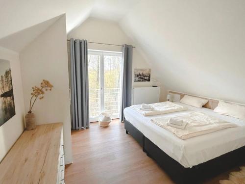 a bedroom with a bed and a large window at Ferienwohnungen PerlePlau in Plau am See
