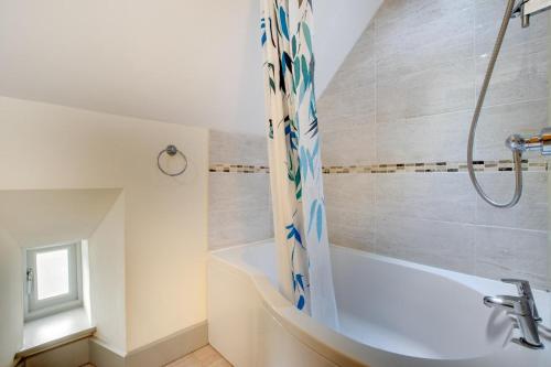 a white bathroom with a tub and a shower at 3 Bed in Totnes oc-bcdart in Broadhempston