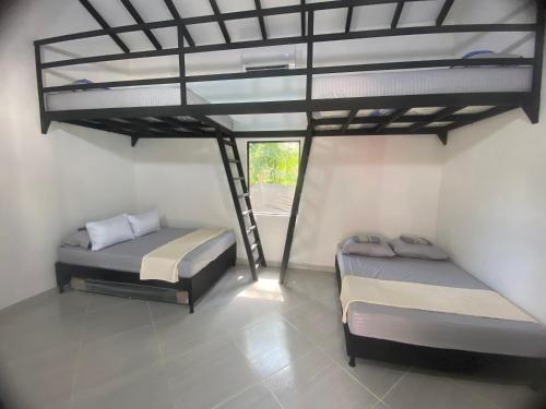 two beds in a room with a loft at Villa Serena Sopetran in Sopetrán