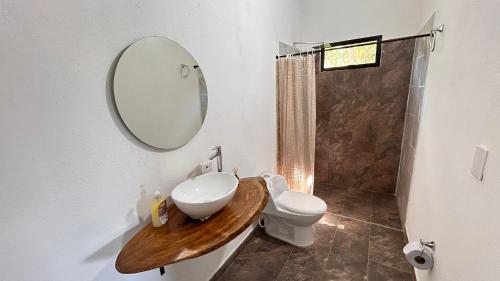 a bathroom with a sink and a toilet and a mirror at Villa Serena Sopetran in Sopetrán