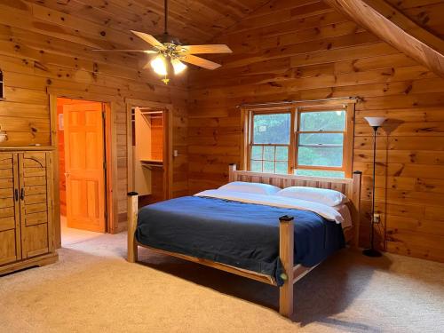 a bedroom with a bed in a log cabin at Rustic Ridge Log Cabin: Hot Tub, Games, Views! in Mount Pocono