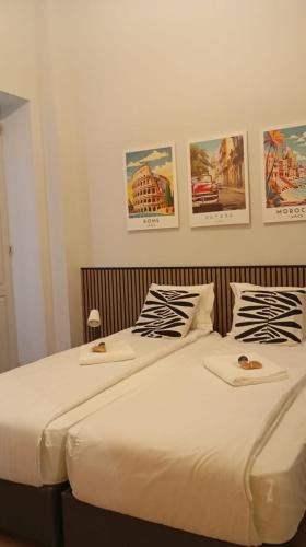 two beds in a bedroom with posters on the wall at Casa Gaea Stay in Braga
