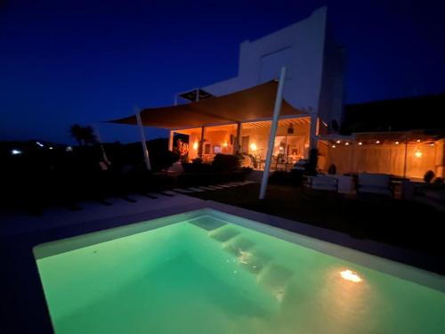 une piscine devant une maison la nuit dans l'établissement CasaEole B&B, à El Haouaria