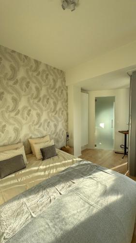 a bedroom with a large bed with a patterned wall at Chez Pomme in Brussels