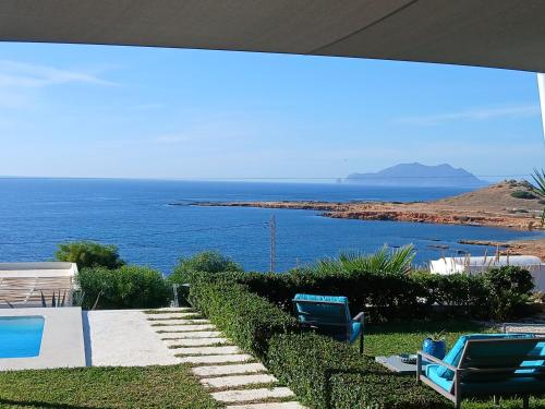 ein Swimmingpool mit zwei Liegestühlen und Meerblick in der Unterkunft CasaEole B&B in El Haouaria