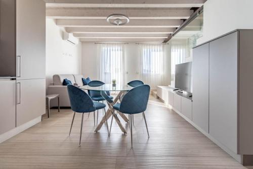 a dining room with a glass table and blue chairs at Apartment-Boutique Stella in Cittadella