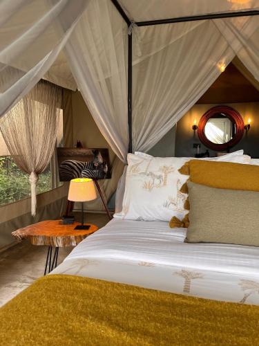 a bedroom with a bed with a canopy at Kampasi Olmoingo Camp in Talek