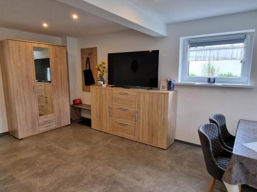 a living room with a flat screen tv on a wooden cabinet at EderseeGlück - Fewo 3 ebenerdig klimatisiert in Edertal