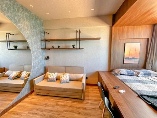 a bedroom with a bed and a couch and a desk at Studio Moderno e Completo in Aracaju