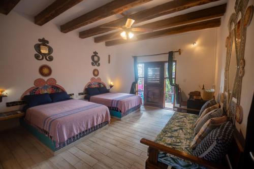 a bedroom with two beds and a ceiling fan at Nacional Beach Club & Bungalows in Mahahual