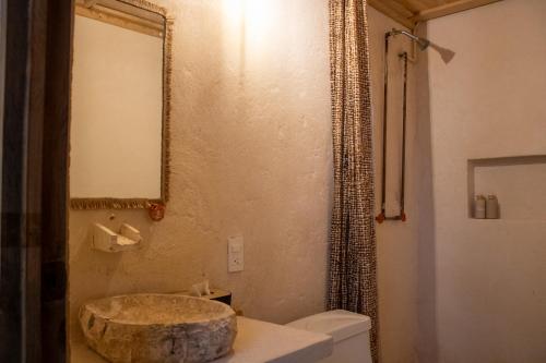 ein Badezimmer mit Waschbecken, Toilette und Spiegel in der Unterkunft Cabañas Tzikin, Telchac Puerto in Telchac