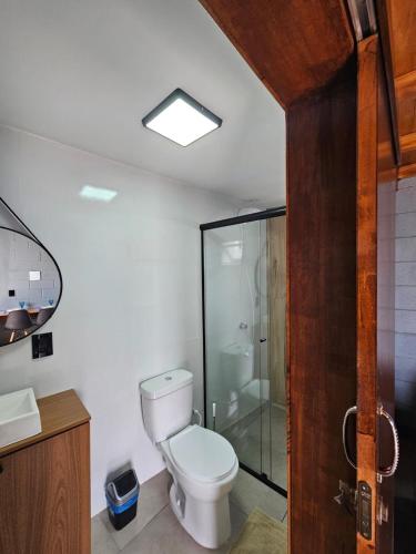 a bathroom with a toilet and a glass shower at Residencial Zille - Lofts e Studios in São Miguel dʼOeste