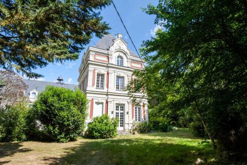a large pink house with trees in front of it at Echappée royale in Saint-Benoît-la-Forêt