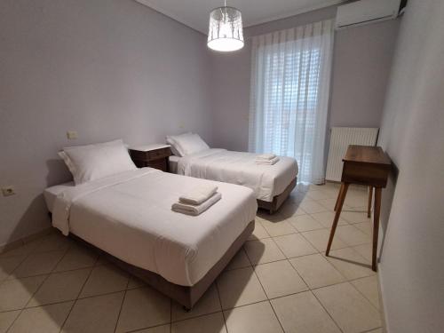 a hotel room with two beds and a table at Marbi Apartment in Tripoli