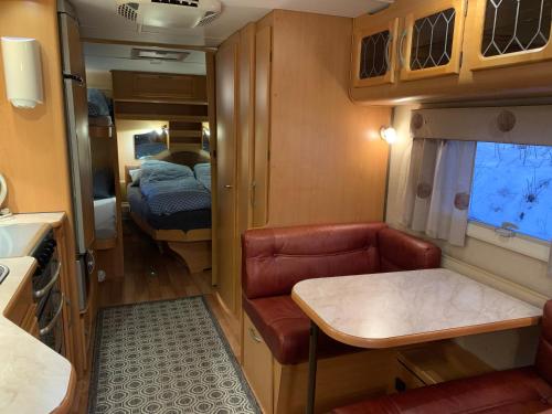 a small room with a couch and a bed at Hagen Camping Mini hus in Kjerrvika